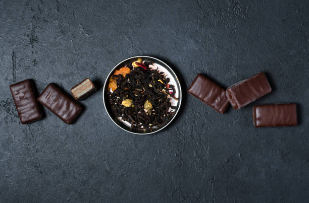 istock Chocolates and black tea with herbs. Dark background. Copy space. Flat lay 1050663062