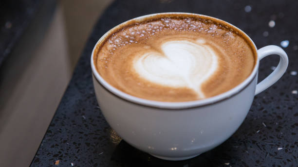 istock Heart-shaped ,Latte Art coffee in a white cup on a black marble table 1050665588