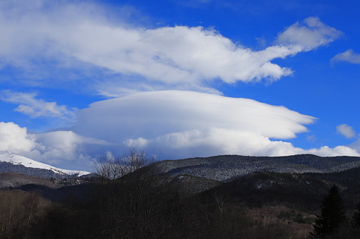 Snow-covered mountain in the Pyrenees covered with lenticular clouds, Aude in the southern France
