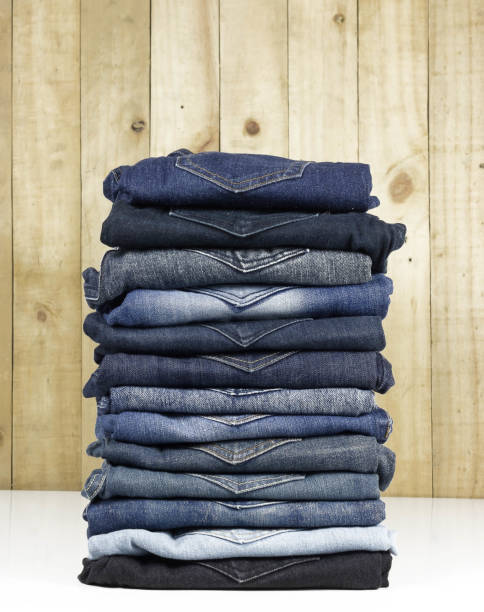 istock jeans stacked on wooden floor. blank background for design and text input. 1050668302