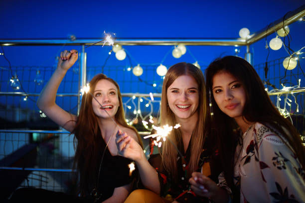 istock 3 young woman with sparklers under blue night sky 1050671770