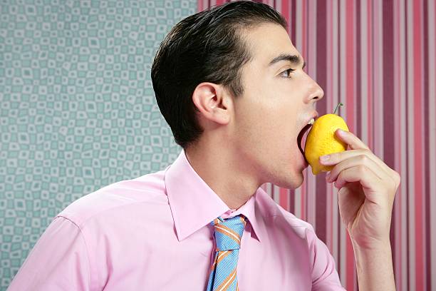 śmieszne biznesmen z cytryna owoców na rękę - lemon sour taste biting eating zdjęcia i obrazy z banku zdjęć