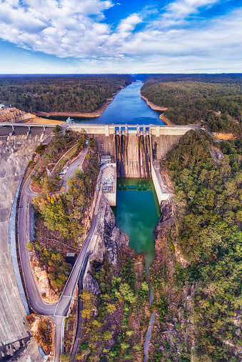 Massive concrete Warraganba dam on Warragamba river forming catchment area to supply fresh water to Greater Sydney - aerial panorama.