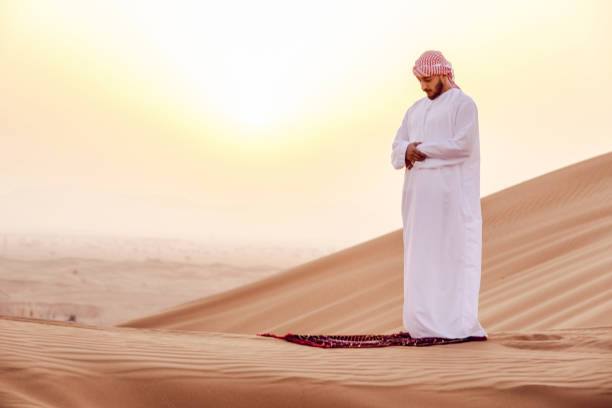 istock Arab man praying at the Sand Dunes during Sunrise 1050686490