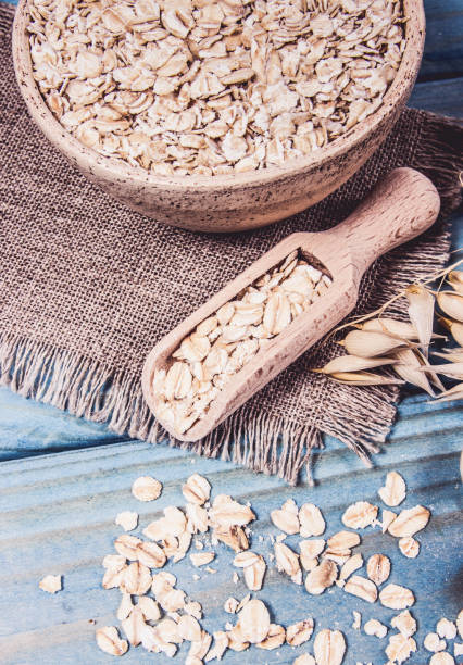 istock Oat flakes in a bowl on the blue board. 1050689306