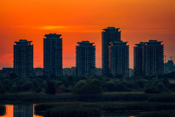 Residential complex located near a lake at sunset with the sun in the background stock photo