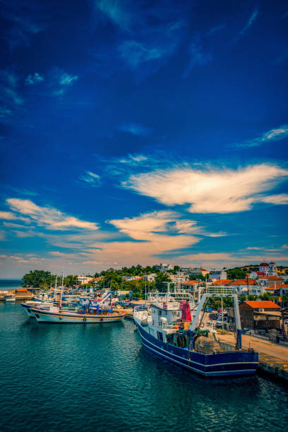 port kamariotissa na wyspie samothrace w grecji w ciągu dnia z tętniącym życiem niebem i pięknymi kolorami w wodzie z dużą ilością łodzi na molo - kamariotissa zdjęcia i obrazy z banku zdjęć