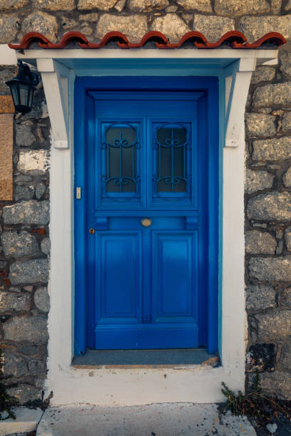 Scenic shot of a picturesque door entrance into a stone house  painted in the greek colours blue and white on Samothrace Island in the city of Samothraki stock photo