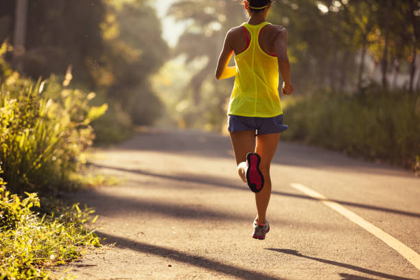 istock Young woman trail runner running on tropical forest trail 1050696566