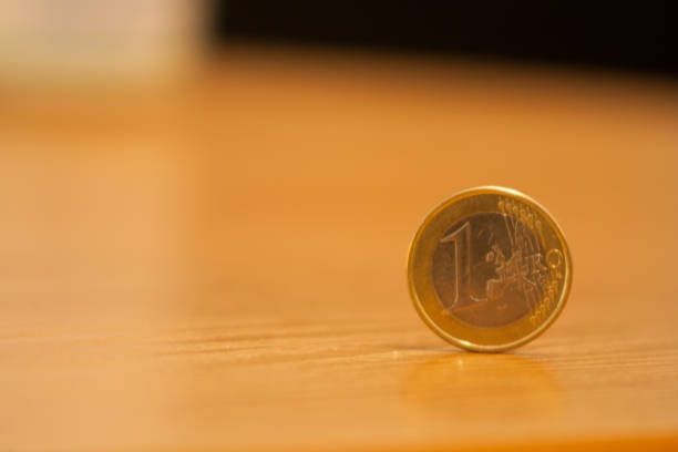 istock close-up 1 euro coin placed on a table, bright background 1050699524