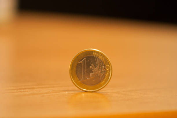 istock close-up 1 euro coin placed on a table, bright background 1050699618