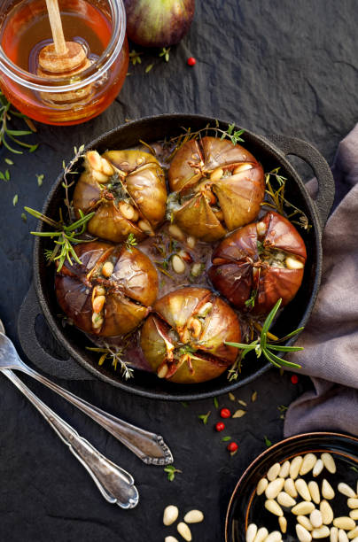 Baked figs stuffed with gorgonzola cheese, pine nuts, honey and herbs in a black dish on a dark, stone background. Baked figs stuffed with gorgonzola cheese, pine nuts, honey and herbs in a black dish on a dark, stone background. Excellent, tasty, vegetarian snack, appetizer plate fig blue cheese cheese stock pictures, royalty-free photos & images