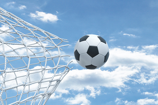 3d rendering of a football ball flying very strongly through a net and breaking it on a sky background. Sport and recreation. Impressive victory. Football match.