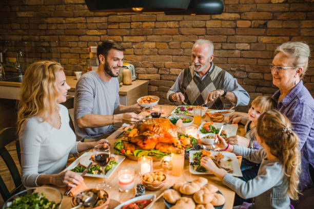 istock Happy multi-generation family enjoying in Thanksgiving dinner at dining table. 1050706822