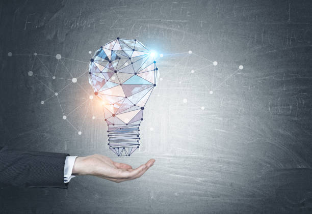 istock Businessman holding light bulb hologram blackboard 1050709874