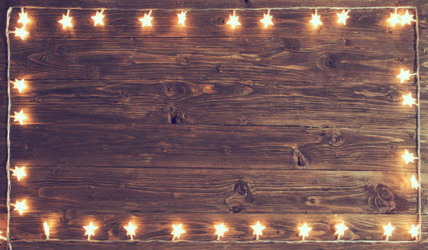 istock Merry Christmas! Christmas lights frame on wooden background with copy space 1050710092