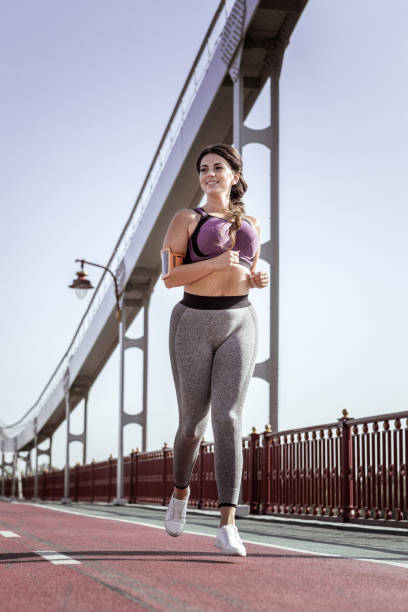 istock Joyful positive woman running on the bridge 1050715844