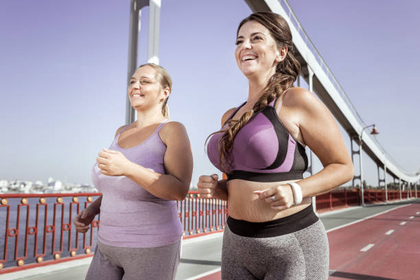 istock Positive joyful women running together on the bridge 1050715882