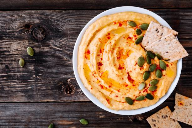 Homemade Savory Pumpkin Hummus . Thanksgiving Appetizer dip Homemade Savory Pumpkin Hummus . Thanksgiving Appetizer dip on wooden background dipping sauce stock pictures, royalty-free photos & images