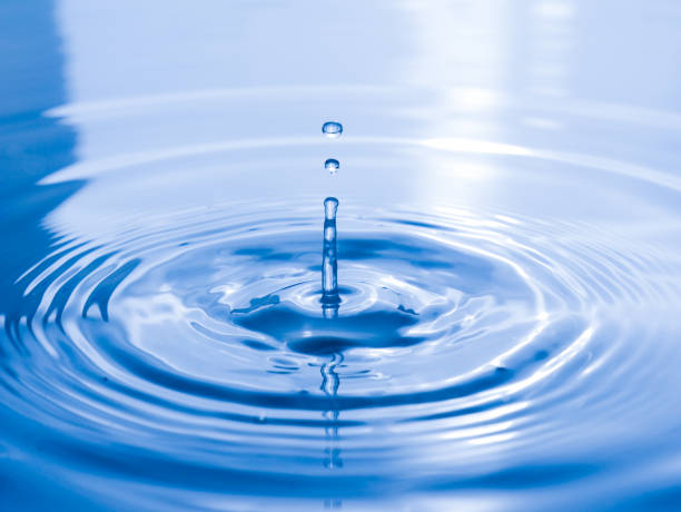 istock close up drop of water on blue background 1050722416