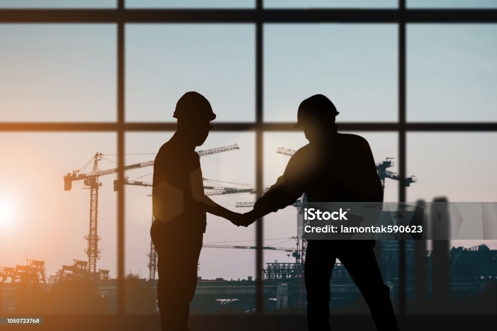 Silhouette of engineer and construction team working at site over blurred background for industry background with Light fair.Create from multiple reference images together Construction Industry Stock Photo
