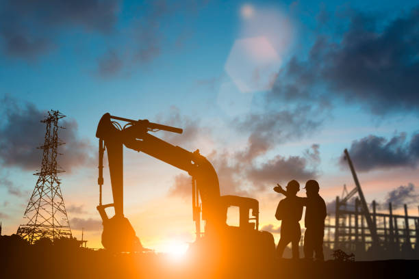 silueta de equipo ingeniería y construcción en sitio sobre un fondo borroso para el fondo de la industria con la luz justa. crear a partir de varias imágenes de referencia - manual worker fotografías e imágenes de stock