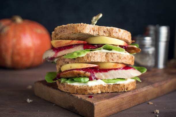 Turkey or Chicken leftover sandwich Turkey or Chicken leftover sandwich with stuffing and cranberry sauce. Freshly made from Thanksgiving or Christmas turkey leftovers on crusty wholemeal bread. sauces table turkey christmas stock pictures, royalty-free photos & images