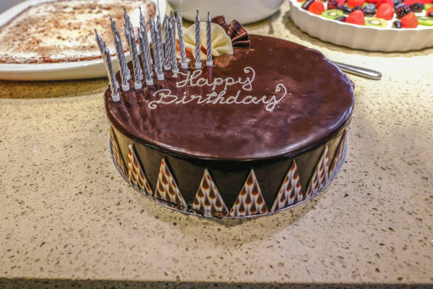 istock Chocolate Birthday cake decorated and dressed with candles 1050725950