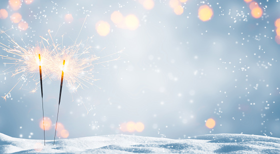 two burning sparklers in snow