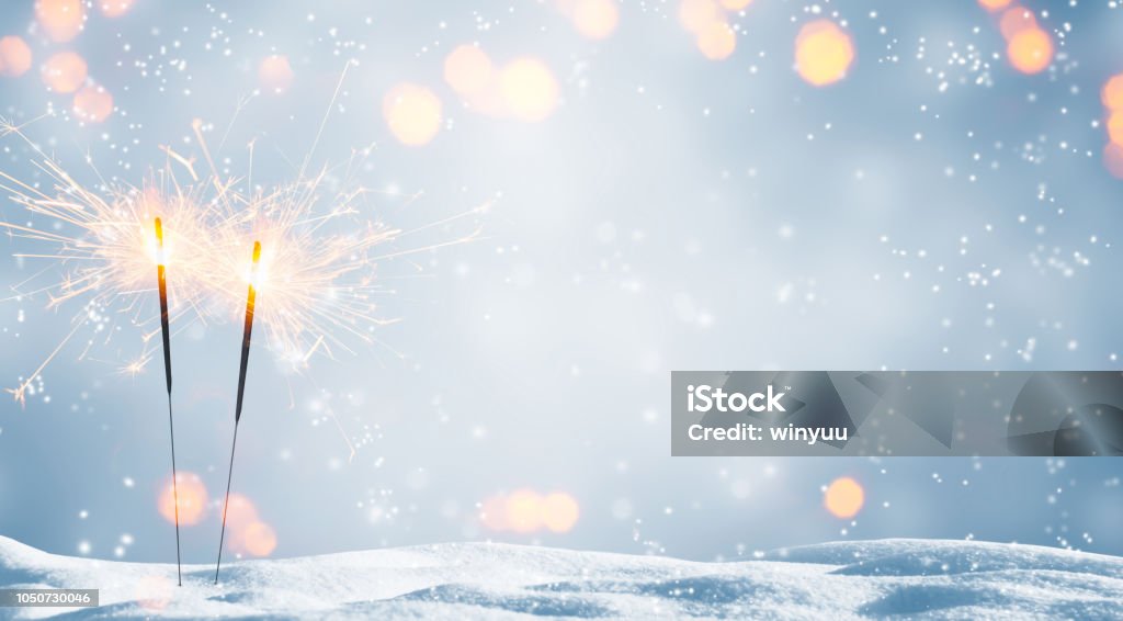 two burning sparklers in snow New Year's Eve Stock Photo