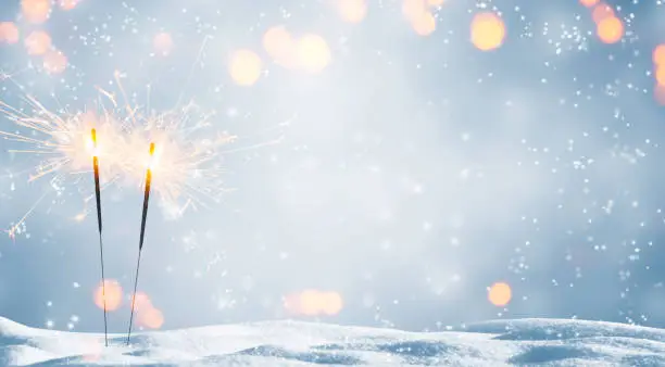 Photo of two burning sparklers in snow