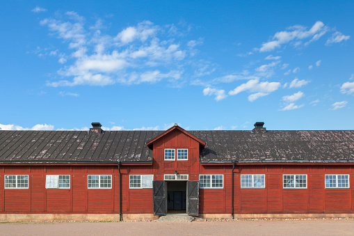 An old stable building with open doors on the swedish countryside.