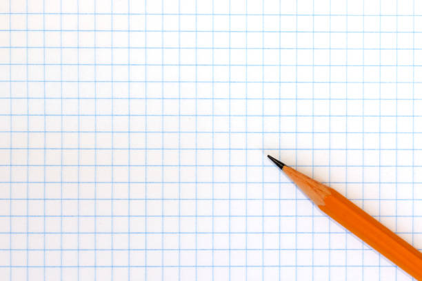 A wooden yellow pencil on checkered exercise book paper with copy space.
