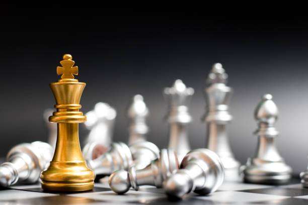 ゴールド キング チェス ピースの別のシルバー チームの顔、黒い背景 (企業戦略、ビジネス勝利または決定の概念) に横たわってポーン - chess king chess chess piece black ストックフォトと画像