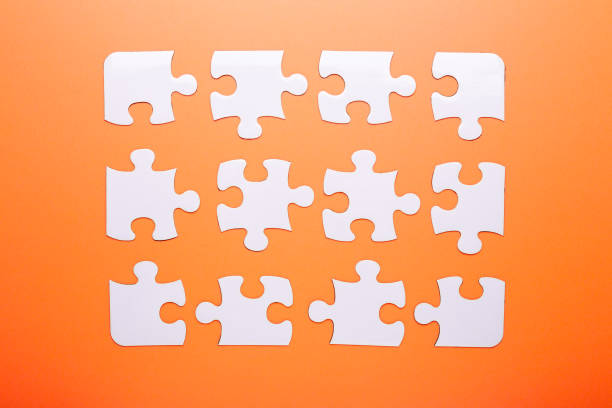 istock White puzzle on orange background. Top view 1050759544