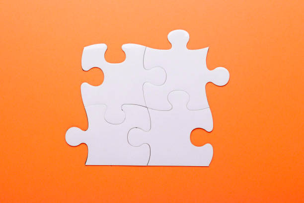 istock White puzzle on orange background. Top view 1050759658