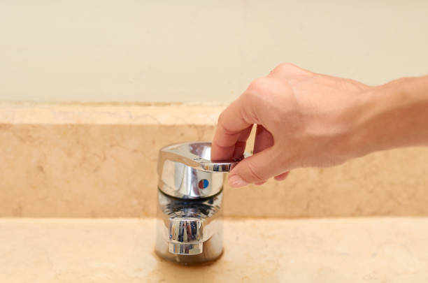 istock marble sink with chromed faucet and hand, bathroom background 1050764274