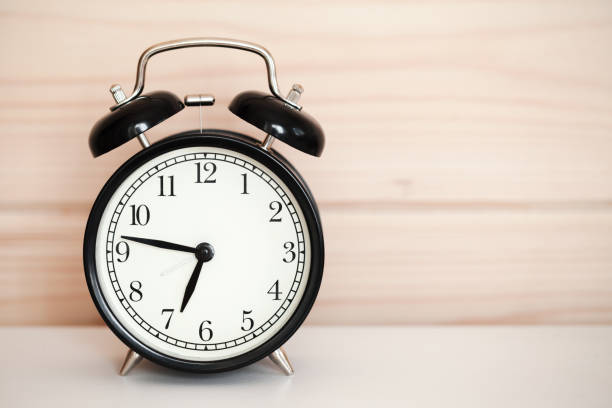 istock Vintage alarm clock is on white bedside table 1050768764