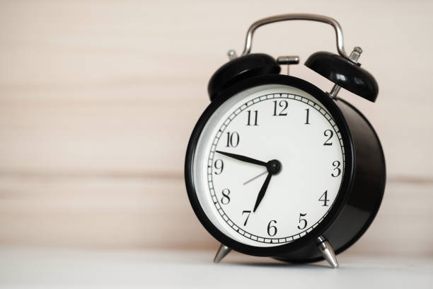 istock Vintage alarm clock is on a bedside table 1050768772