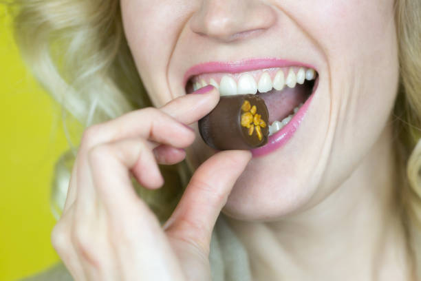 istock A woman with a beautiful smile is eating candy. 1050770460