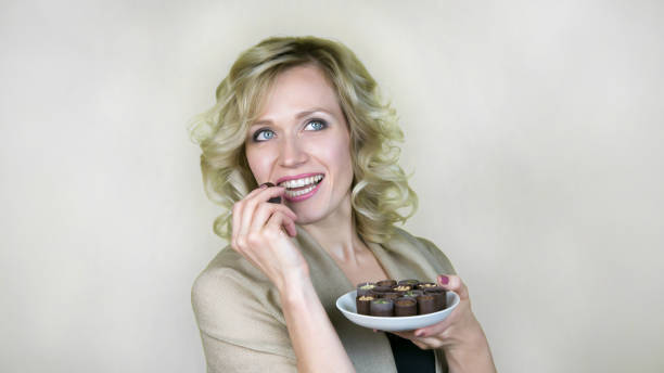 istock A woman with a beautiful smile is eating candy. 1050773130