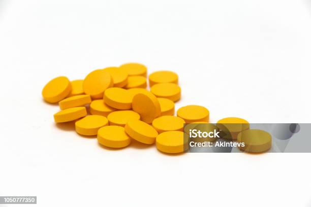 Many Yellow Pills On White Background Stock Photo - Download Image Now - Capsule - Medicine, Heap, Orange Color