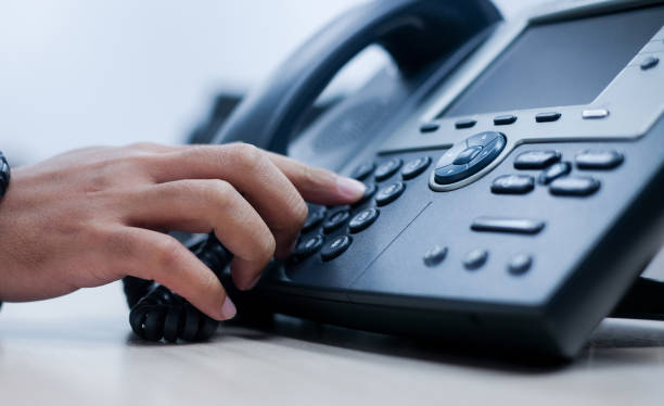 close-up ponto de mão de homem empregado para pressionar o botão número na mesa de escritório telefone para contato do cliente ou colegas no conceito de empregado empresa .hotline - telefone fixo - fotografias e filmes do acervo