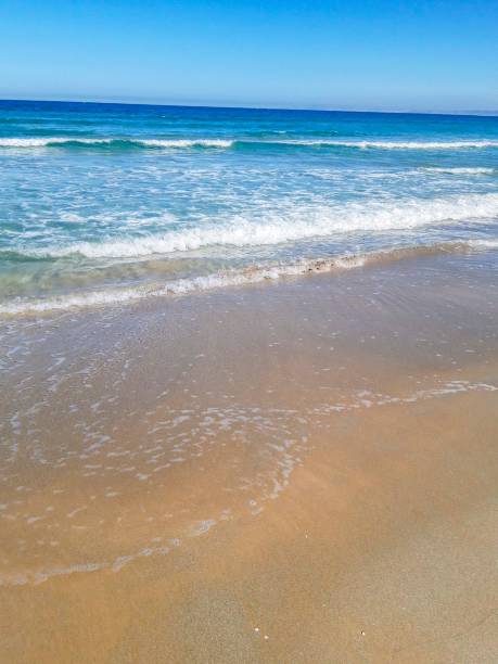 istock Empty sand beach with blue sea and blue sky background. 1050787994