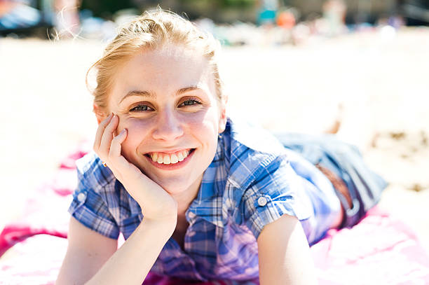 mujer joven relajante en la playa - high key portrait color image travel locations fotografías e imágenes de stock