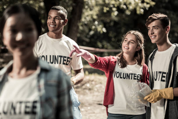 istock Dark-haired girl standing with her friends while volunteering in forest 1050790136