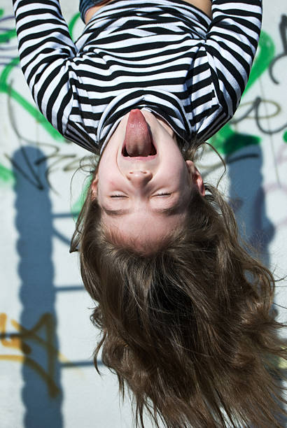 naughty funny girl upside down on the playground stock photo