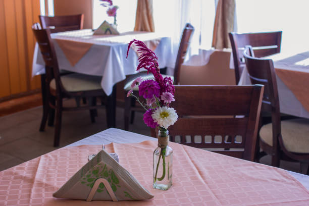 istock table in the restaurant with pink flowers on the table and brown chairs 1050797732
