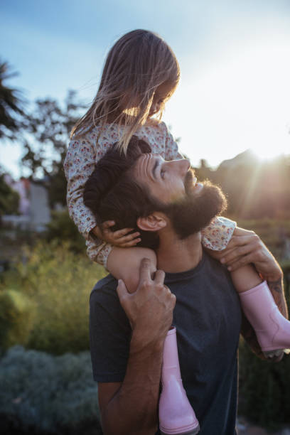 istock Father carrying his daughter on shoulders at field 1050800166