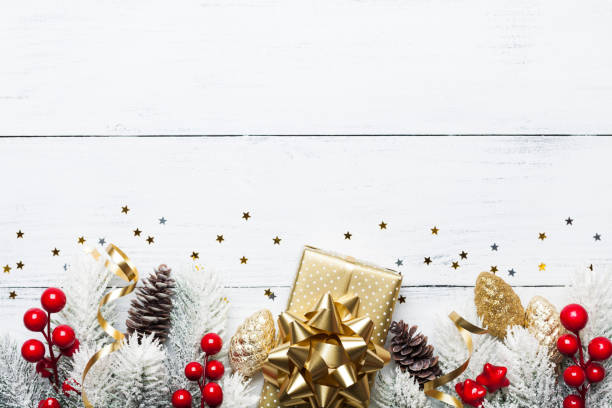 istock Gift or present box, snowy fir tree and Christmas decorations on white wooden table top view. 1050807162